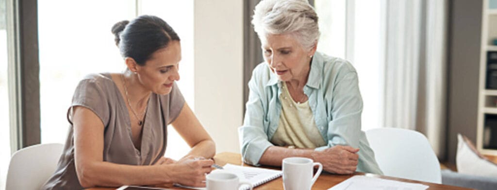 A woman sits with her mother to discuss finances