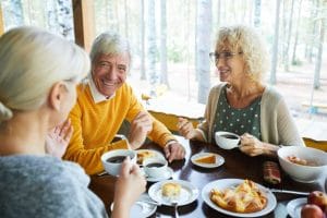 A group of friends sit inside and enjoy breakfast together