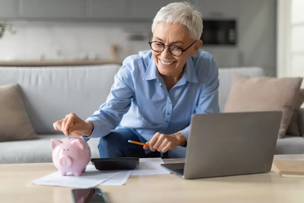 Senior woman adding money to piggy bank