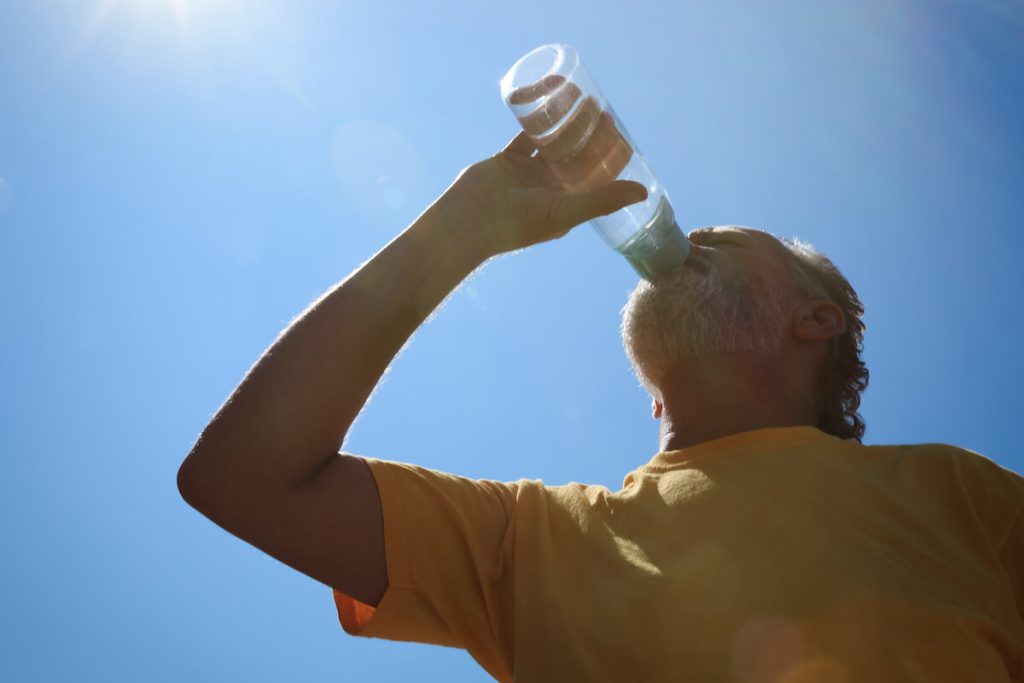 Senior drinking water outdoors