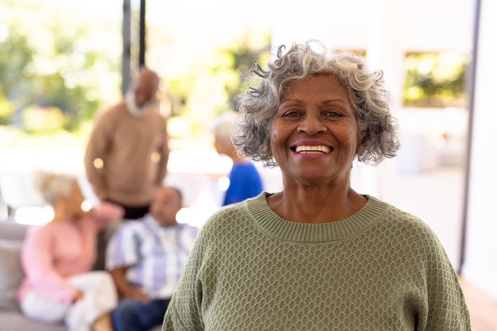 Smiling older woman with a group of friends in the background