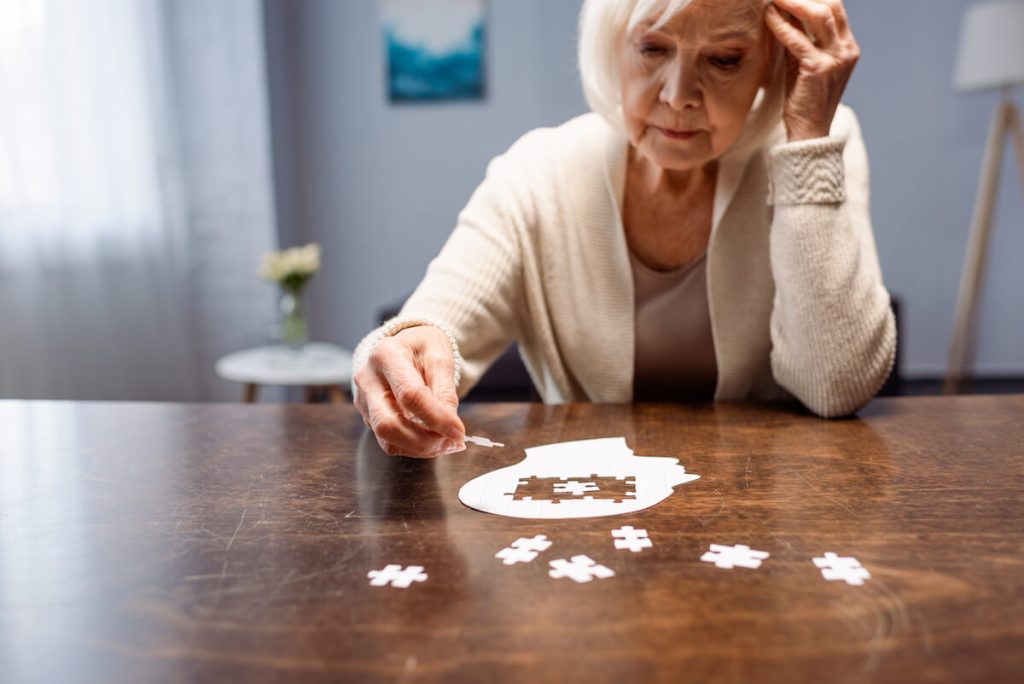 Older woman putting together a brain puzzle