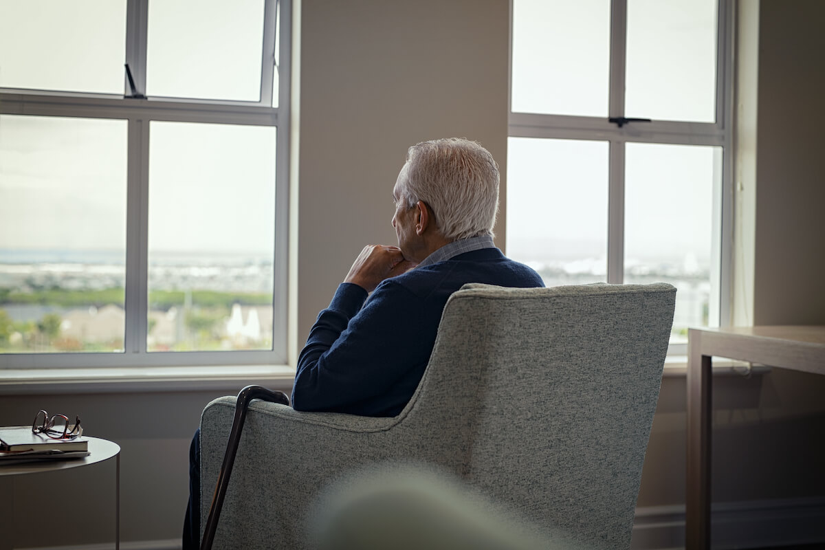 Older adult looking through the window