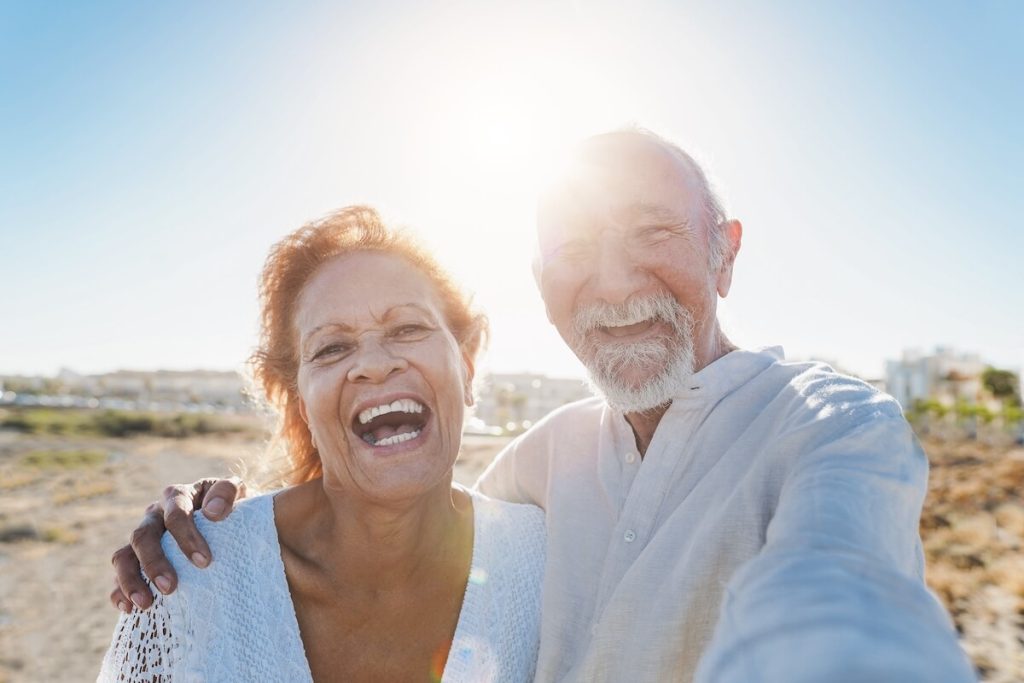 Smiling couple of seniors at the beach